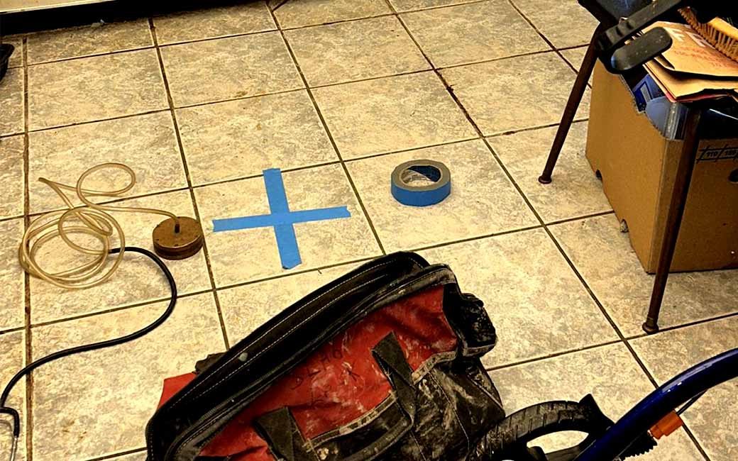 Homeowner noticing warning signs of a slab leak in a Texas home, including warm floors and water damage